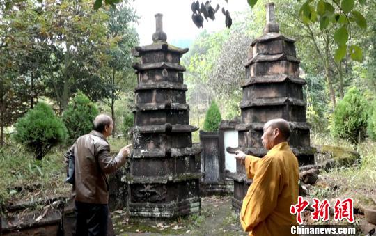 龙岩寺住持(右)向文史专家介绍双子墓塔。 徐志雄 摄