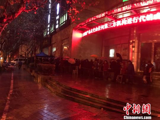 1月5日清晨5点半,在上海静安邮政支局,市民冒着寒风与冷雨,撑伞排队,抢购首发的戊戌狗年生肖邮票。 郭容 摄