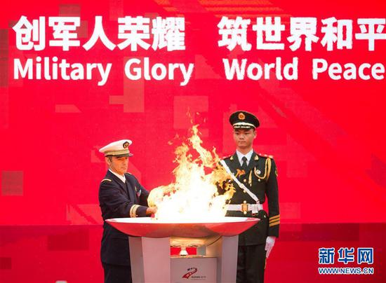 10月16日,国际军事体育理事会主席赫尔维·皮奇里洛(左)点燃第一支火炬。当日,第七届世界军人运动会火炬传递活动在武汉东湖绿道举行。新华社记者 肖艺九 摄